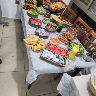 שולחן ערוך עם מגוון מאכלים, ירקות ולחמים