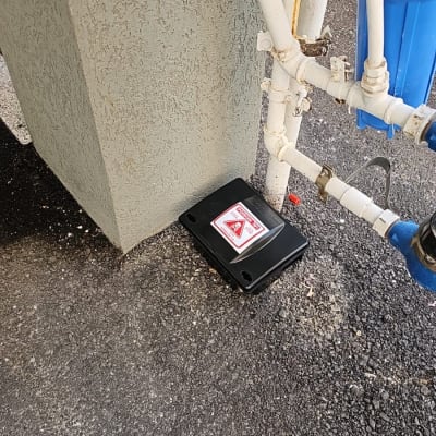 קופסת הדברה שחורה עם סימן אזהרה על הקרקע