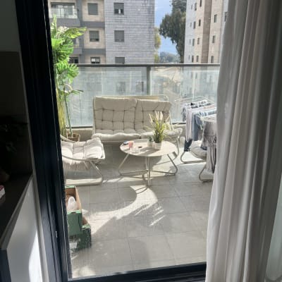 מעקה אלומיניום במרפסת עם רהיטים וצמחים