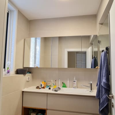 Bathroom with mirror, sink, and toiletries.