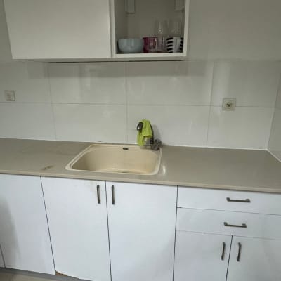 כיור ומטבחון עם ארונות לבנים וברז