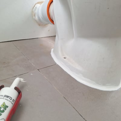 חיבור צינור עם חומר איטום ליד אסלה