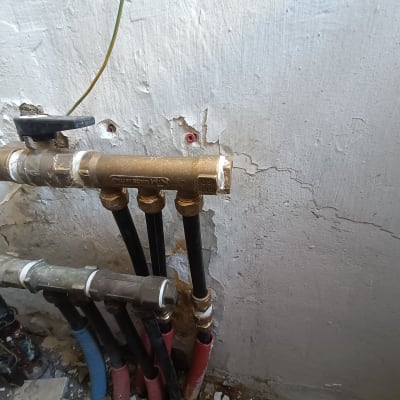 צינורות מים עם ברזים על קיר בטון