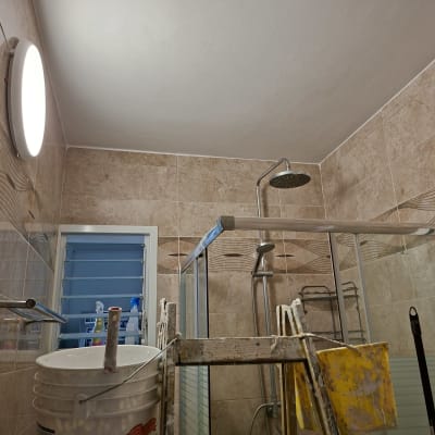 חדר אמבטיה עם סולם, דלי וכלי עבודה לאיטום