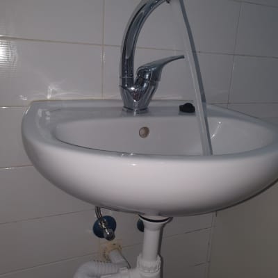 כיור עם ברז פתוח וצנרת מתחת