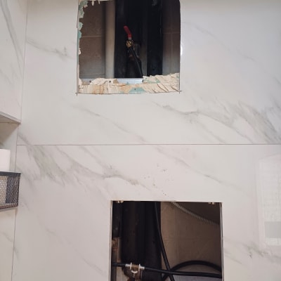 צינורות מים חשופים בקיר עם ברז אדום