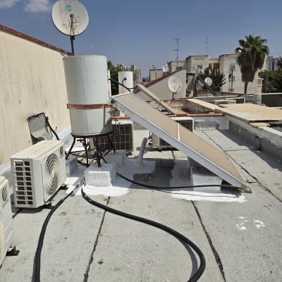 גג עם דודי שמש ומזגנים, עבודת איטום נראית בבירור