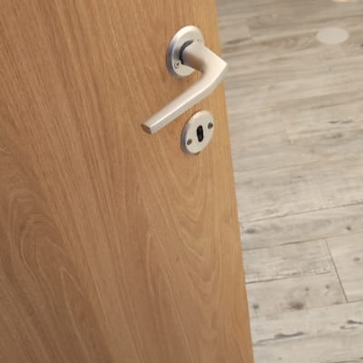 ידית דלת מתכתית על דלת עץ