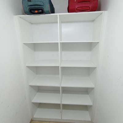 ארון מדפים לבן עם מזוודות למעלה