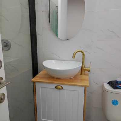 כיור עגול על ארון עץ עם ברז זהב