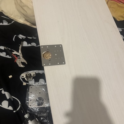 כלי עבודה וחלקים על שולחן, כולל מקדחה ומחברים.