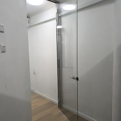 דלת זכוכית שקופה עם ידית מתכת בחדר מואר