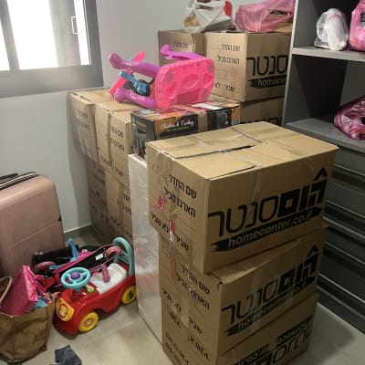 קופסאות קרטון וצעצועים בחדר עם מדפים
