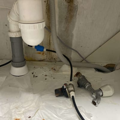 צנרת מתחת לכיור עם חיבורים ודליפה