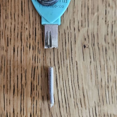 מפתח שבור עם מספר טלפון על רקע עץ