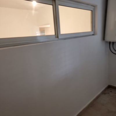 קיר צבוע עם חלון קטן ותאורה פנימית