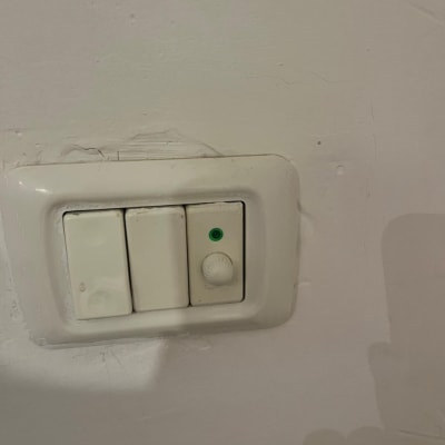 מתג חשמל עם כפתור דימר על קיר לבן