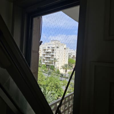 חלון אלומיניום פתוח עם רשת בטיחות