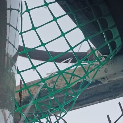 רשת ירוקה על צינור עם טיפות מים