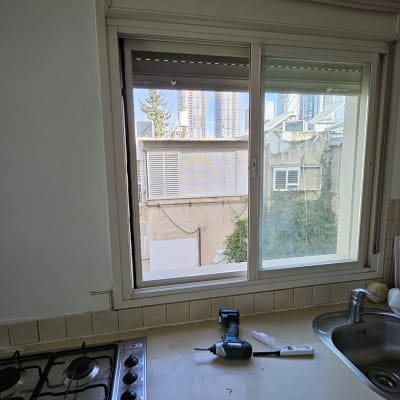 חלון אלומיניום עם כלים על השיש במטבח