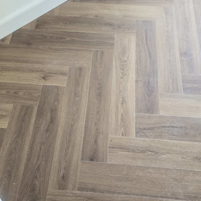 רצפת פרקט בעיצוב פישבון בגווני עץ טבעיים