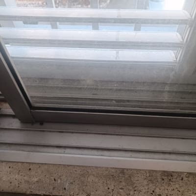 תריסים אפורים עם מסגרת מתכת וחלון זכוכית