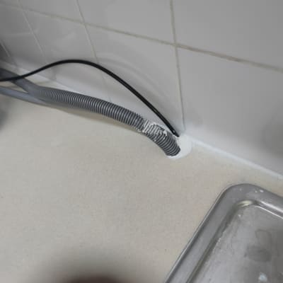 צינור גמיש מחובר לקיר מעל כיור