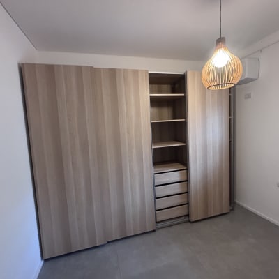 ארון עץ עם מדפים ומגירות בחדר מואר