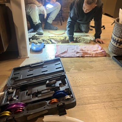 שני אנשים עובדים על התקנת מזגן עם כלים וצינור