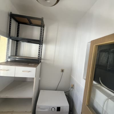 מכונת כביסה ומדפים בחדר שירות