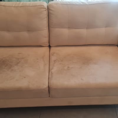 ספת בד בצבע קרם עם כתמים קשים על כריות הישיבה לפני ניקוי