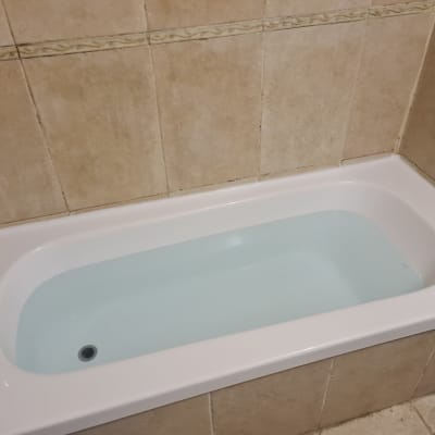 אמבטיה עם מים מוקפת באריחי קרמיקה חומים