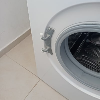 דלת מכונת כביסה פתוחה עם תוף מתכת