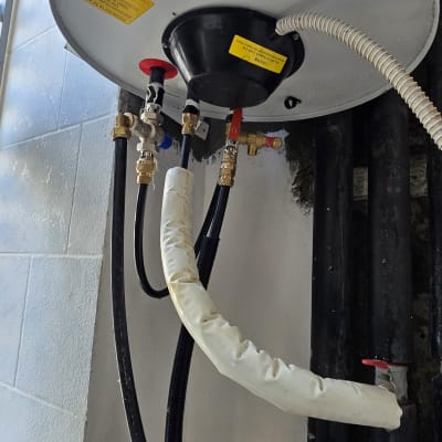 דוד שמש עם צינורות וחיבורים מותקנים על קיר