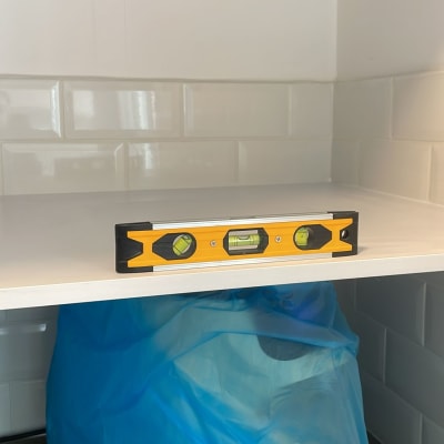 פלס על מדף במטבח עם אריחים לבנים