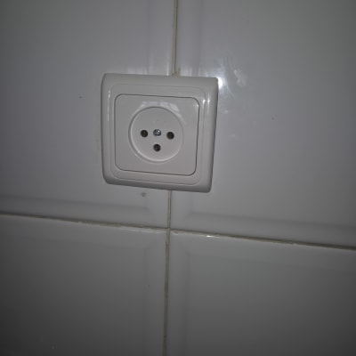 שקע חשמלי לבן מותקן על קיר אריחים
