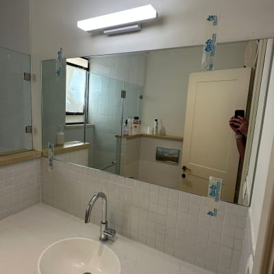 מראה בחדר אמבטיה עם כיור וברז