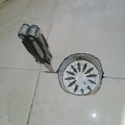 פתח ניקוז ברצפה עם כלי עבודה