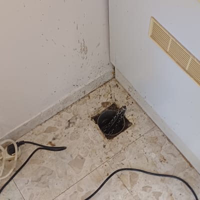 פתח ניקוז עם שרשרת על רצפה מלוכלכת