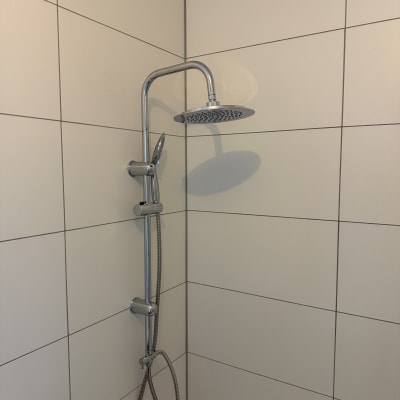 מקלחת עם ראש מקלחת וכותלי קרמיקה