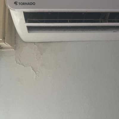 מזגן מותקן על קיר עם קילופי צבע