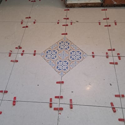 ריצוף קרמיקה עם מרווחים ומרצפת מעוטרת במרכז