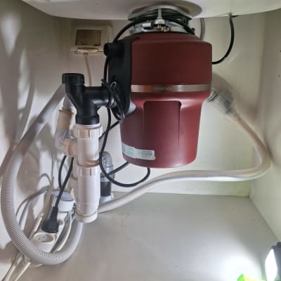 מערכת טוחן אשפה מתחת לכיור עם צינורות חיבור