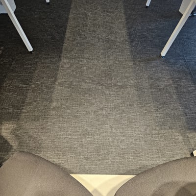 שטיח אפור נקי בין שולחנות לבנים