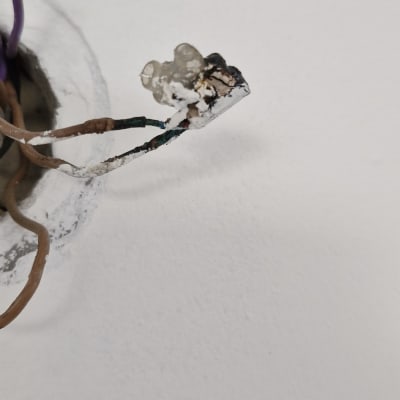 חוטי חשמל חשופים יוצאים מקיר לבן