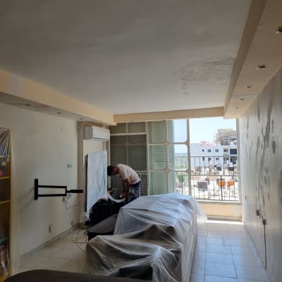 חדר עם אדם עובד, רהיטים מכוסים בניילון