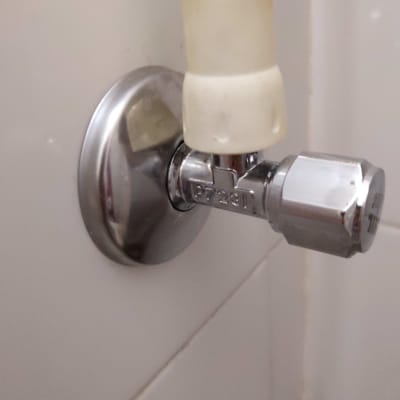 ברז מתכת עם צינור מחובר לקיר