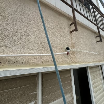 צינור לבן מחובר לקיר עם חומר איטום