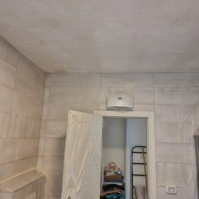 חדר עם קירות ותקרה מוכנים לצביעה, דלת מכוסה בניילון