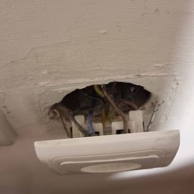 חוטי חשמל חשופים בקיר עם מתג